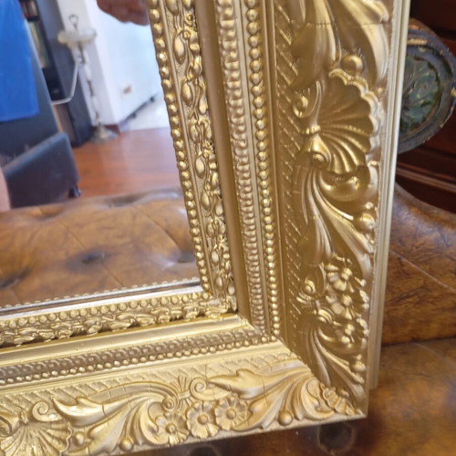 Baroque wall mirror with carved gold frame and embossed motifs