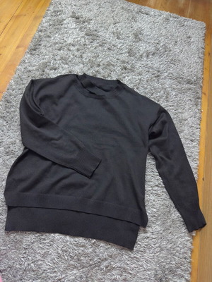Knitted women's black sweater used with asymmetrical hem