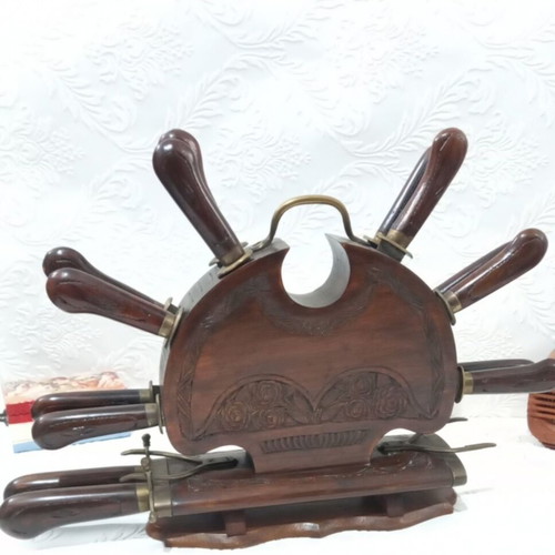 Wooden carved stand with used set of knives and forks
