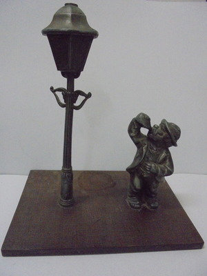 Vintage decorative composition used, metal figure and street lamp on wood base