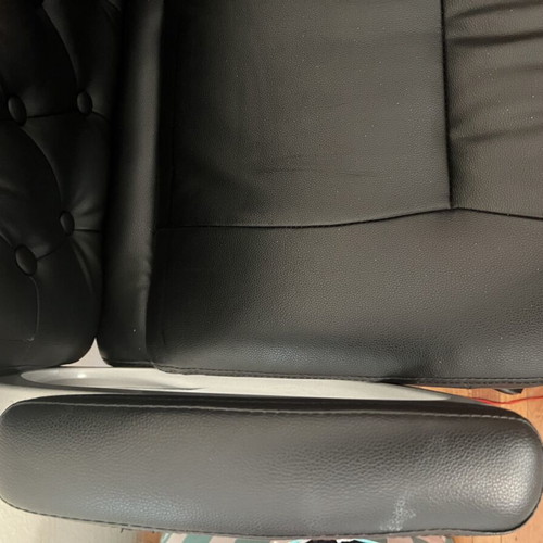 Office chair with black faux leather upholstery and button-tufted back