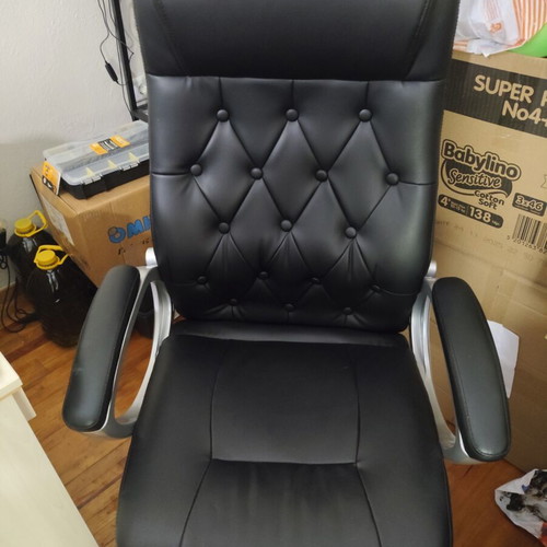Office chair with black faux leather upholstery and button-tufted back