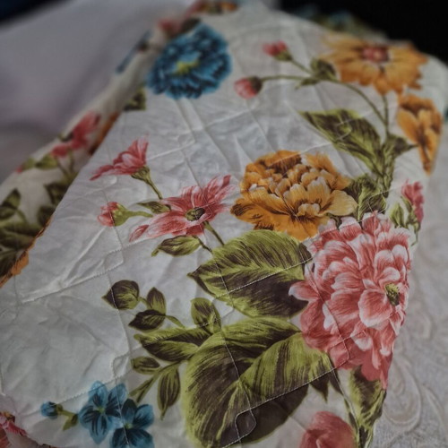 Vintage quilt with floral design, cream background