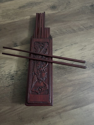 Japanese wooden box with 16 used chopsticks and palm carving