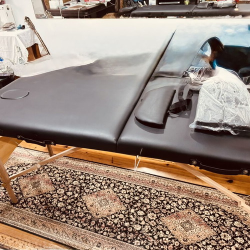 Portable folding massage bed with vinyl mattress, wooden frame