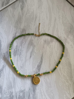 Necklace with green beads and gold-colored pendant like new
