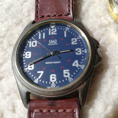 Q&Q wristwatches used with brown leather straps, blue one has glass damage