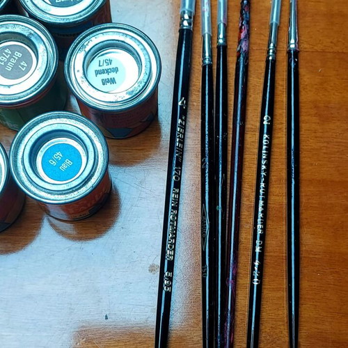Various jars with colors and brushes