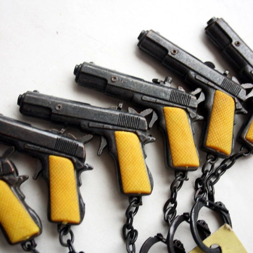 Card with 12 vintage 80's Colt 45 metal pistol keychains new