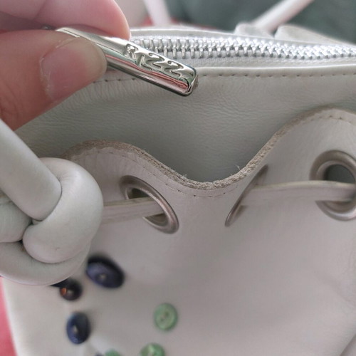 White bucket handbag used with decorative buttons