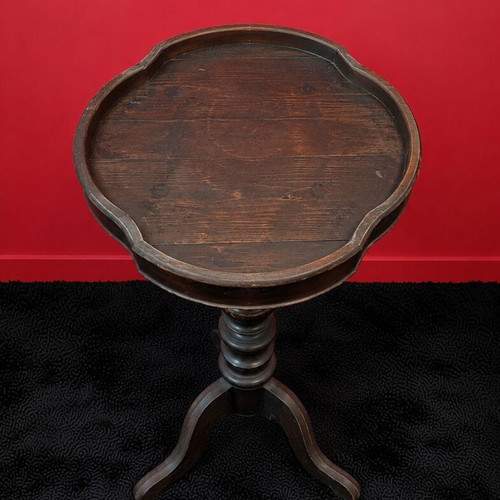 Round wooden table used with ornate base