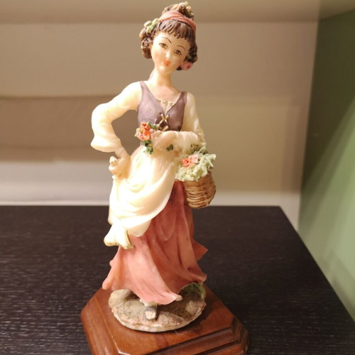 Porcelain figure used with wooden base and girl carrying flowers