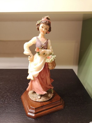 Porcelain figure used with wooden base and girl carrying flowers