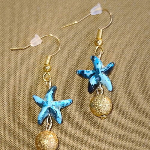 Handmade gold-tone earrings with blue starfish