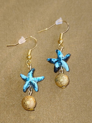 Handmade gold-tone earrings with blue starfish