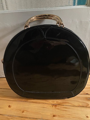 Round black glossy handbag like new with gold handles