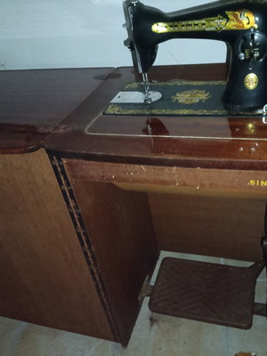 Singer antique sewing machine with wooden cabinet and treadle, used