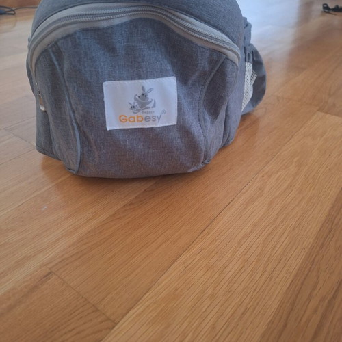 Gabesy ergonomic hip seat carrier used with branded baby toys