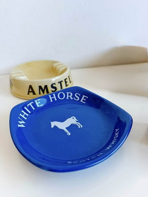 Set of 2 collectible porcelain ashtrays, Amstel and White Horse