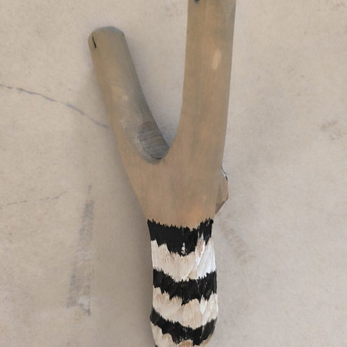 Handmade wooden slingshot with carved raccoon