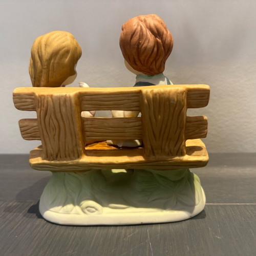 Porcelain decoration with two children on bench like new