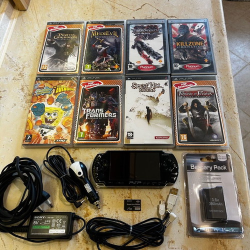 Sony PSP-2004 console with 8 game cartridges and accessories set