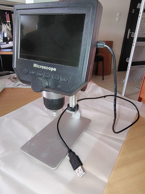 Digital bench microscope with adjustable height and built-in lighting