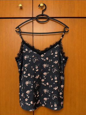 Satin top with floral pattern on black base and lace details used