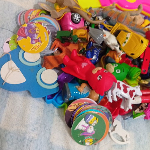 Box of various used children's toys including pop-it and wooden drum