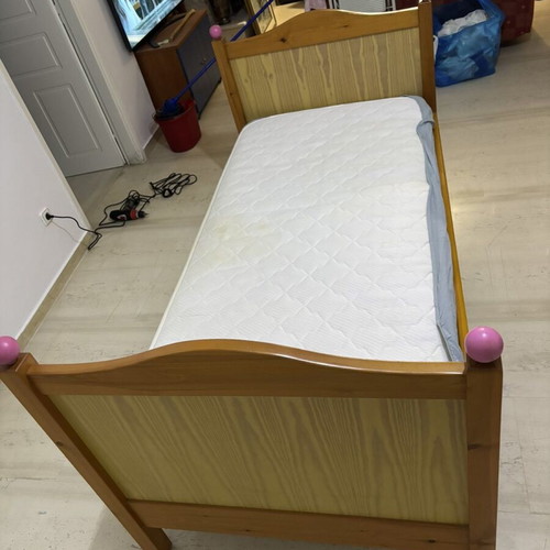 Single wooden bed with mattress, natural wood finish, pink details