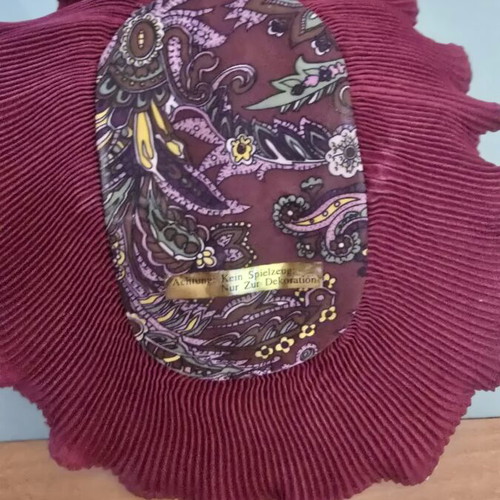 Decorative porcelain wall mask used with fabric hat in burgundy