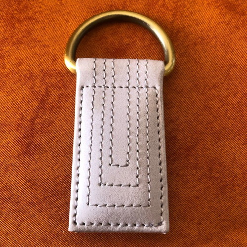 Keychain with intricate design in white, new