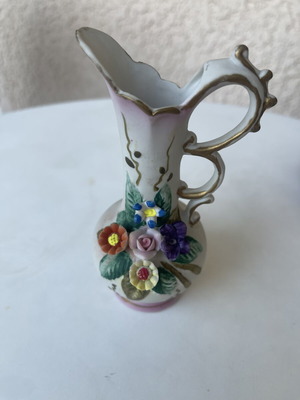 Vintage ceramic pitcher with embossed flowers used