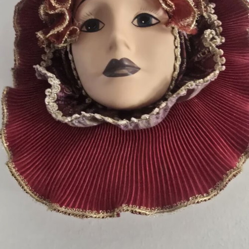 Decorative porcelain wall mask used with fabric hat in burgundy
