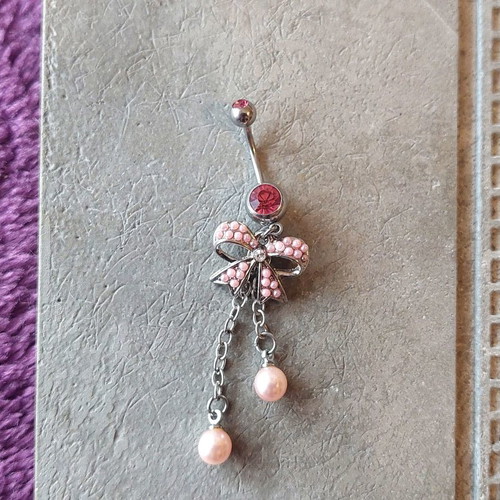 Girlie navel piercing with pink details and bow