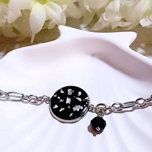 Handmade steel bracelet with iridescent black motif and silver flakes