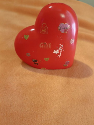 Heart-shaped piggy bank used with stickers and paint wear