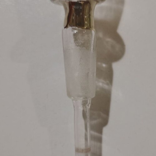 Glass perfume bottle used with golden accents and cap