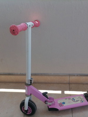 Pink children's scooter used with wear but fully functional
