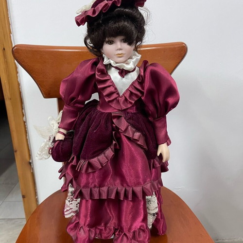 Porcelain doll used with satin and velvet dress, broken arm