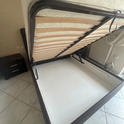 Double bed with brown leatherette upholstery, storage and lift mechanism