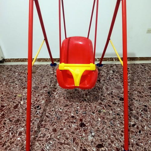 Child swing with metal frame and plastic seat, used with plastic wear