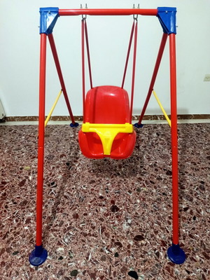 Child swing with metal frame and plastic seat, used with plastic wear