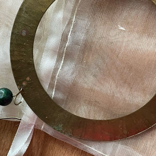 Handmade earrings used, round flat with green bead decoration