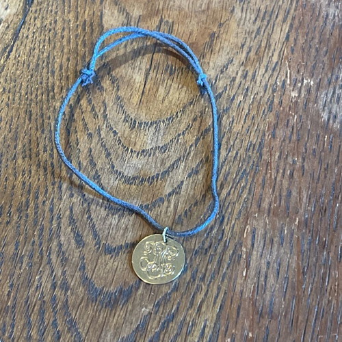Adjustable length bracelet used, cord with gold detail