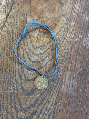 Adjustable length bracelet used, cord with gold detail