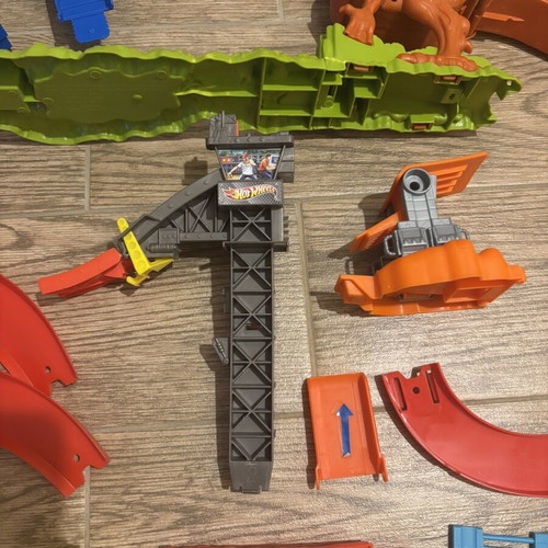 Hot Wheels track set pieces with T-Rex figure and launcher