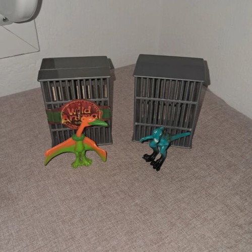 Dinosaur figures used, set in cages