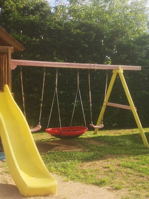 Playground set used with trampoline, seesaw, slide, and swings