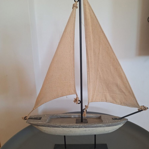 Decorative wooden sailboat with fabric sails and wooden lighthouse used